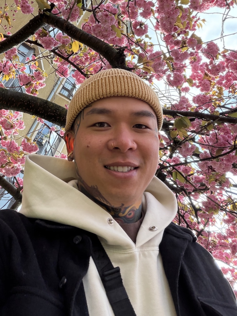 Brian Divine beneath pink cherry blossoms